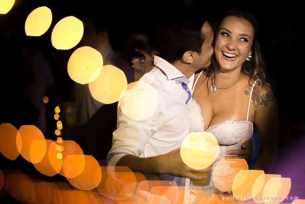 Foto de Casamento na praia de Larissa e Ronaldo beijo no pescoço durante a festa